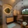Revonia underground sauna interior – wood-paneled vault with arched window, bathtub and bathroom in earth-sheltered wellness retreat