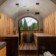 Revonia underground sauna with wooden benches and forest view – earth-sheltered sauna interior with traditional stone stove