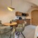 Revonia underground house open-plan interior – dining table, kitchen and bedroom in compact arched vault modular home
