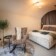 Revonia underground house bedroom – cozy double bed with arched vault ceiling and armchair in earth-sheltered modular home